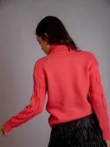 Polera blanca de punto con cuello alto y diseño trenzado.