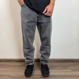 Jean de hombre color negro con efecto lavado, de corte mom fit, con cintura elástica y puños ajustados en los tobillos.