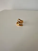 Anillo dorado con diseño en espiral y abertura superior.
