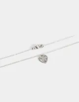 Collar multicadena plateado con dije de corazón calado y dije de cuentas cilíndricas.