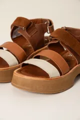 Sandalias de cuero marrón con plataforma y tiras de cuero marrón, beige y blanco.