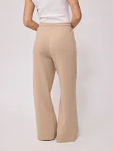 Pantalón deportivo jogger color beige, de pierna ancha y corte holgado.