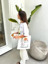 Bolso tote color beige con estampado de tazas de café y la palabra "croissants".