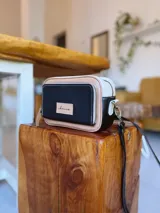 Bandolera rectangular combinada en color negro, beige y blanco, con correa larga regulable y bolsillo exterior con cierre.