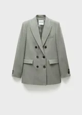 Blazer gris cruzado con cuello de pico con solapa, tejido de mezcla de lana, diseño recto y largo, manga larga con puños abotonados, forro interior y bolsillos de ribete en el pecho y de solapa laterales.