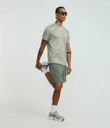 Bermuda deportiva color verde oliva, confeccionada en tejido tecnológico con toque leve y elástico. Cuenta con cintura elástica, cordón interno, bolsillos laterales y estampado reflectivo lateral.