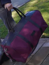 Bolso de lona color verde militar con detalles en cuero marrón. Tiene doble asa de mano y correa de hombro ajustable y extraíble.