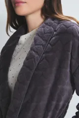 Bata larga de poliéster color gris oscuro con textura acolchada en forma de rombos, cuello tipo chal, bolsillos laterales y cinturón.