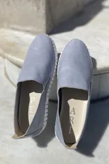 Slippers de cuero celeste con elásticos laterales y suela de goma blanca.