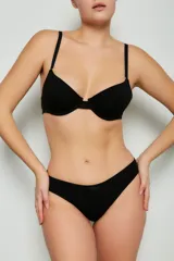 Conjunto de ropa interior negro, compuesto por un corpiño con aro y breteles regulables, y una bombacha vedetina clásica mediana.