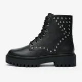 Bota de cuero negra con caña media, cordones y plataforma track. Presenta apliques de tachas plateadas en el lateral exterior.