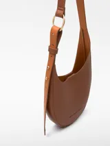 Bandolera pequeña color tostado, con textura granulada, un compartimento y cierre magnético. Tiene asa larga regulable y logo grabado.