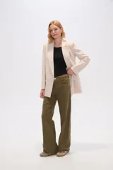 Blazer color beige de lino, con cuello solapa, corte holgado y bolsillos laterales.