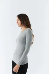 Remera gris de punto canalé, con escote redondo y mangas largas.