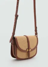 Bandolera de rafia color beige con detalles en cuero marrón, cierre de botón magnético y correa ajustable.