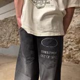 Pantalón jean super baggy color gris oscuro con bordado en el bolsillo trasero.