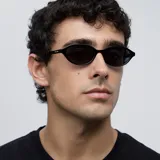 Lentes de sol con montura ovalada negra y lentes polarizadas negras. Fabricados con materiales bio-based G850 y patillas de propionato de celulosa. Protección UV 400.