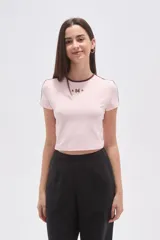 Remera cropped de manga corta, color negro, con cuello redondo ribeteado en blanco y estampado frontal de estrellas y el número "94" en blanco.