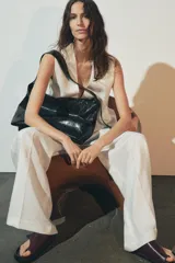 Bolso shopper marrón de efecto acharolado con asa de hombro ajustable, bolsillo interior con cremallera y cierre magnético.