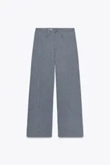Pantalón de vestir celeste con corte palazzo, tiro alto, bolsillos laterales y cierre frontal con cremallera y botón.