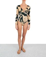 Entero de lycra color verde con estampado de flores beige, con mangas largas y escote en V con detalle de nudo.