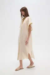 Túnica color crema de algodón con mangas cortas anchas, cuello en V y cordón ajustable.