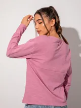 Remera básica de color azul marino, de manga larga con detalle fruncido en el cuello y bolsillo frontal, de corte holgado.