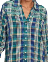 Camisa de manga larga con estampado de cuadros en tonos verde, azul marino y amarillo. Presenta un canesú bordado en la parte superior del pecho y hombros con diseño geométrico en tonos verdes y blancos.