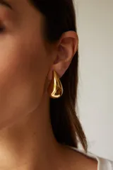 Aros colgantes dorados con forma de gota.