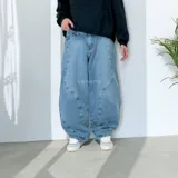 Pantalón de jean celeste, corte ultra baggy, con costuras curvas decorativas en los laterales.