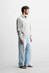 Sudadera color crema de corte recto, con cuello polo y cierre de cremallera metálica.