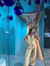 Pantalón color arena, de corte recto y tiro alto, confeccionado en lino.