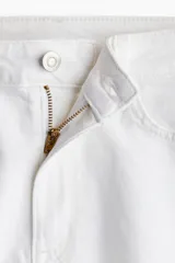 Short blanco de denim de algodón levemente elástico, con cinco bolsillos, tiro alto, corte relajado y cierre con botón.