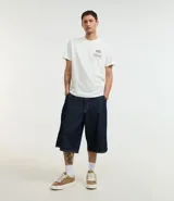 Remera blanca de algodón, corte comfort, con cuello redondo y mangas cortas. Estampa en la espalda con una garza, texto en japonés y la frase "flow like the wind".