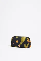 Neceser Bimba y Lola de nylon negro con estampado de cactus y flores naranjas. Tiene asa extraíble, piezas de piel, logo metálico, bolsillo interior y cierre con cremallera dorada.