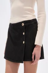 Short de jean negro, tiro alto, con diseño cruzado frontal abotonado con botones dorados.