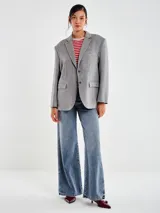 Blazer de mezcla de lana color gris oscuro, con apliques tipo joya en forma de puntos dispuestos en líneas verticales. Presenta solapas de muesca, cierre frontal de un solo botón y bolsillos de parche delanteros.