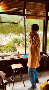 Gabardina larga color camel de cuero ovino italiano, con cuello alto y bolsillos laterales.