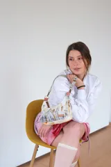 Cartera tipo baguette confeccionada en algodón con estampado abstracto en tonos blanco, gris y marrón. Tiene correa desmontable con mosquetones y bolsillo interno.