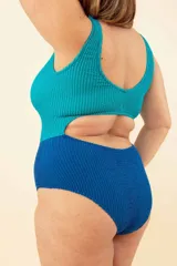 Malla entera combinada en tonos azul y verde, con corte triangular en el frente y nudo en el escote.