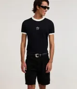 Bermuda de sarga para hombre en color rosado, de corte slim. Presenta bolsillos laterales y traseros, presillas para cinturón y cierre frontal con botón y cremallera.