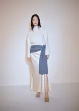 Sweater de poliéster color crudo, con cuello alto y mangas largas.