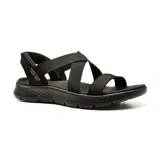 Sandalia deportiva Skechers Slip-ins Go Walk Flex Glimmer, color negro, con tiras elásticas cruzadas y talón descubierto. Cuenta con plantilla contorneada Goga Mat, amortiguación Ultra Go y tecnología Hands Free Slip-ins.