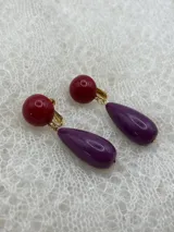 Par de aros colgantes con base redonda color borgoña y dije en forma de lágrima color violeta.
