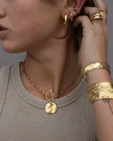 Aro earcuff plateado y dorado con diseño texturizado que simula lava.