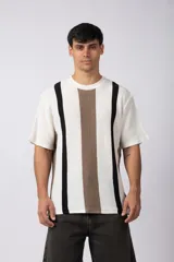 Remera de hombre tejida en algodón color crudo, con textura piqué y rayas verticales marrones y negras.