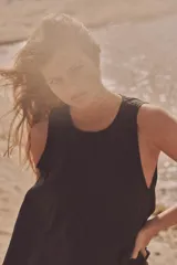 Vestido midi negro de tejido fluido, con cuello redondo y sisa. Cierre trasero con cremallera oculta.