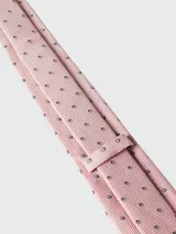 Corbata de seda color rosado claro con microestampado de cuadros y pequeños círculos concéntricos en negro y blanco.