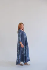 Vestido largo de lino color azul con estampado floral, corte amplio, mangas 3/4 y cuello en V.