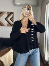 Cárdigan color beige de tejido de punto calado con mangas largas y corte holgado.